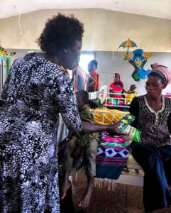 Director giving items to the patients